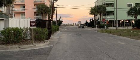 A street with a row of multi-story buildings, a stop sign, and a sign for 'Sun Skipper'.