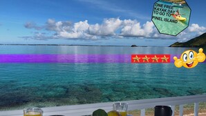 En fantastisk utsikt över havet, ett bord med frukt och dryck, och en skylt som berättar om en dag då man kan använda kajakerna gratis för att åka till ön Pinel.