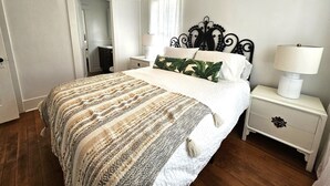 A neatly arranged bedroom with a large bed, a bedside table with a lamp, and a wardrobe. - Charming Beach Cottage, 2 blocks from the water! (Morro Bay)