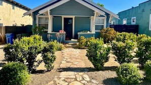 A single-story house with a front porch, a stone pathway, and well-maintained bushes. - Charming Beach Cottage, 2 blocks from the water! (Morro Bay)