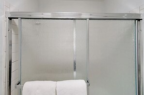 Duschwanne, Handtücher, Shampoo, Toilettenpapier