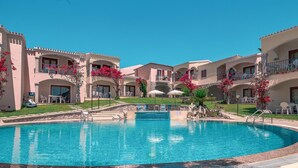 A resort with a central swimming pool, multiple balconies, and outdoor seating areas. - 2 bedroom lovely apartment in Badesi (Badesi)