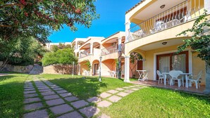 A hotel with a paved courtyard, outdoor seating, and a stone pathway. - 2 bedroom lovely apartment in Badesi (Badesi)