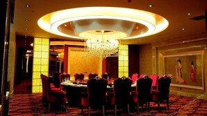 A formal dining room with a round table, red chairs, and a chandelier. - Long Xin International Hotel (Lanzhou)