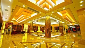 A spacious lobby with a central reception desk, large pillars, and a polished floor. - Long Xin International Hotel (Lanzhou)
