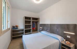 Ein Schlafzimmer mit einem Bett, einem Kleiderschrank und einem Nachttisch.