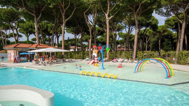 A swimming pool with a water slide, lounge chairs, and a restaurant area. - Stunning home in Lido di Spina FE with swimming pool (Lido di Spina FE)
