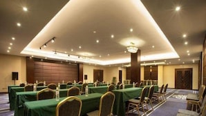 A conference room with multiple tables and chairs, equipped with microphones and water bottles. - Qiaodu Hotel (Jiangmen)