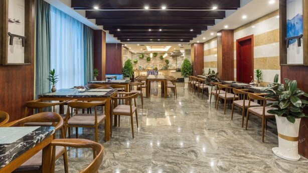 A spacious hotel lobby with multiple dining areas, marble flooring, and wooden furniture. - Lifeng Tangguo Hotel (Jinhua)