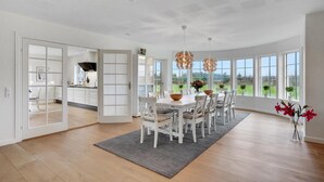 A spacious dining area with a high ceiling and large windows offering a view of the outdoors. - 6 bedroom cozy home in Grindsted (Grindsted)