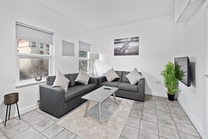 Departamento, 2 habitaciones | Área de sala de estar | Smart TV de 42 pulgadas con canales digitales, televisión y Netflix 