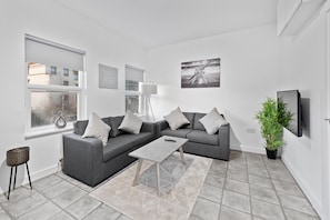 Departamento, 2 habitaciones | Área de sala de estar | Smart TV de 42 pulgadas con canales digitales, televisión y Netflix