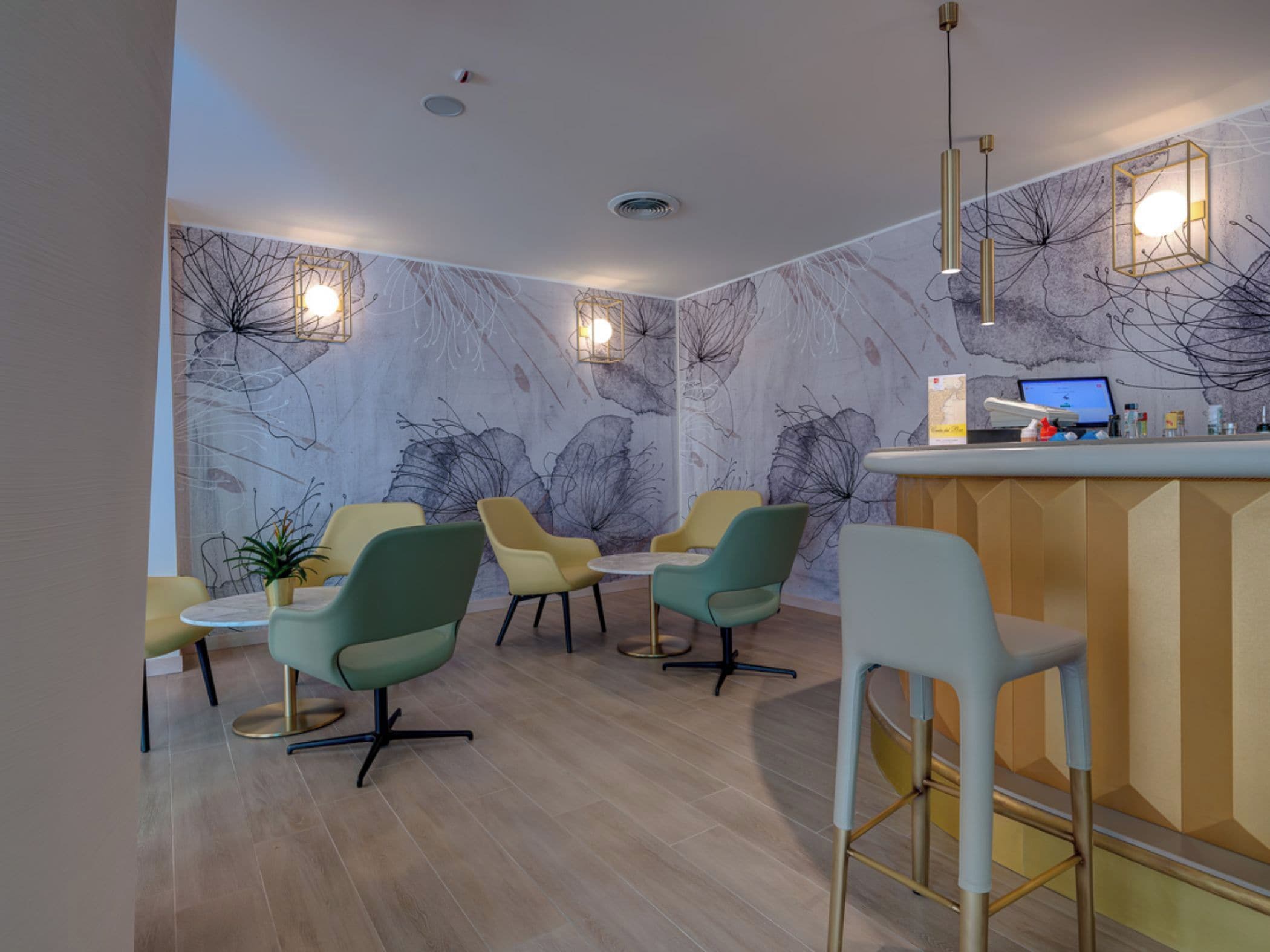 Un interno moderno con un'area bar, diverse opzioni di seduta e decorazioni a parete.