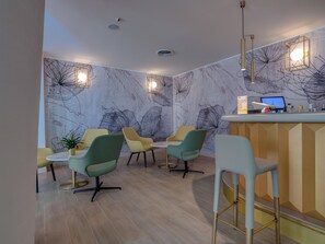 A modern interior with a bar area, multiple seating options, and decorative wall art. - Antares (Letojanni)