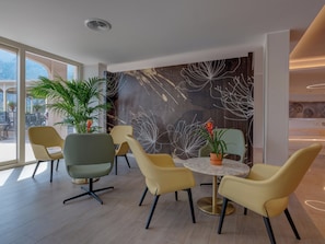 Un comedor moderno con una mesa redonda, sillas amarillas y una planta grande en maceta.