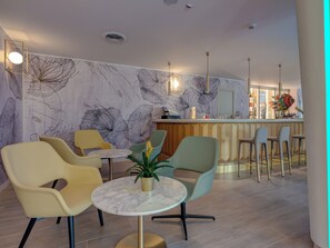 A modern bar area with a marble-top table, bar stools, and a decorative plant. - Antares (Letojanni)