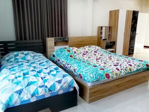 A bedroom with two beds, a wardrobe, and a mirror. - Lena Chalet (Nakhon Ratchasima)