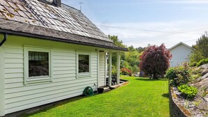 A single-story house with a sloped roof, a front porch, and a well-maintained lawn. - Gorgeous home in Reksteren with kitchen (Reksteren)