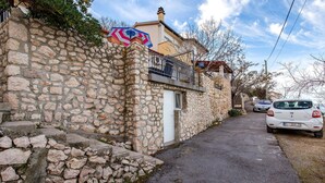 Un étroit sentier de pierre menant à un bâtiment doté d’un balcon.