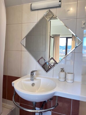 A bathroom with a white sink, a chrome faucet, and a large mirror with a diamond frame. - Apartment Josipa Vela Luka (Vela Luka)