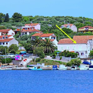 A coastal town with houses, a marina, and a yellow arrow pointing to a building. - Apartment Josipa Vela Luka (Vela Luka)