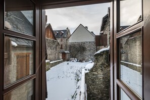 Une cour pavée, recouverte de neige, avec des bâtiments en arrière-plan.