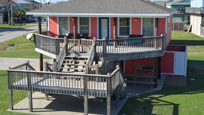 A two-story building with a balcony and a small deck area.