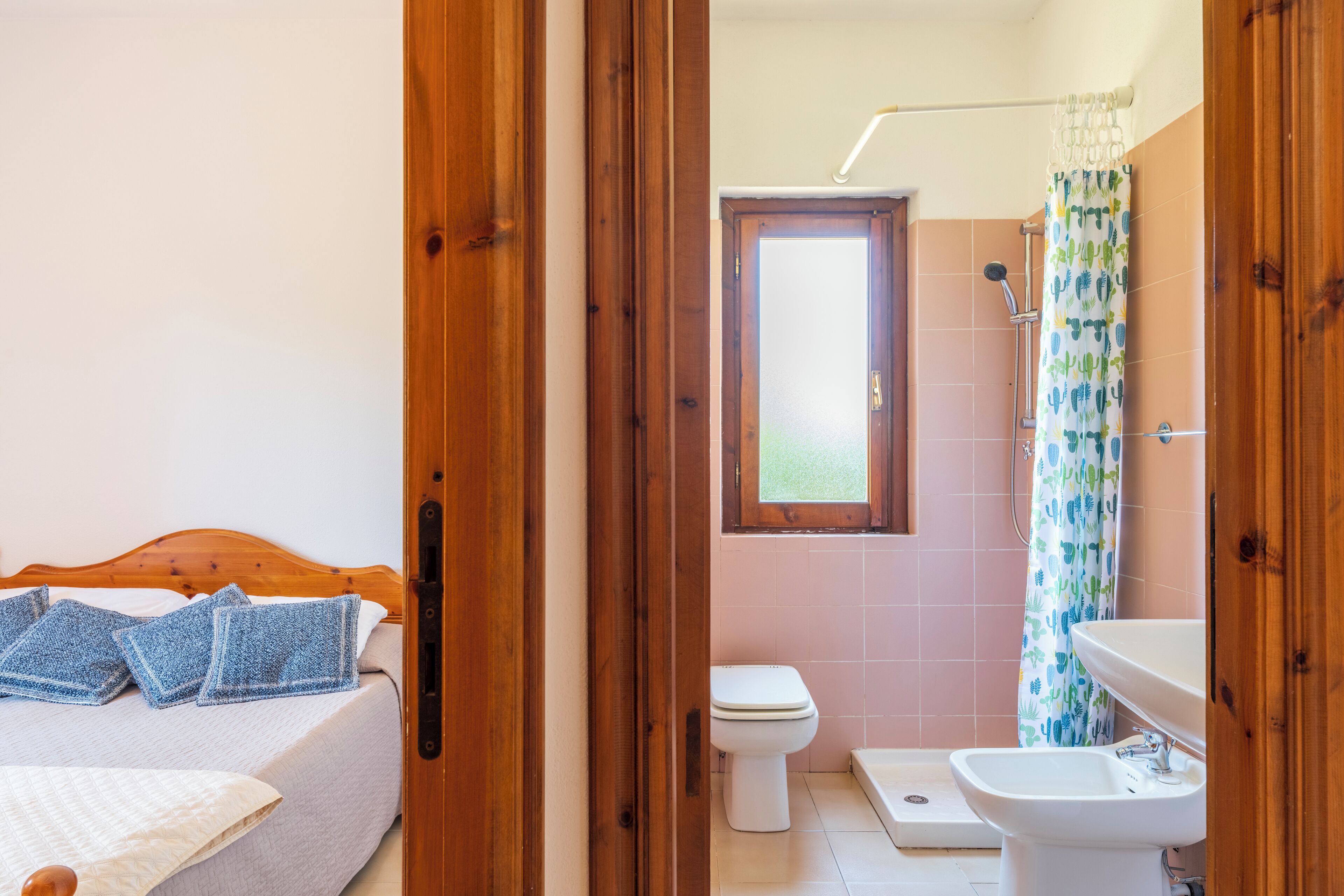 A bedroom with a wooden bed, a bedside table, and a window.