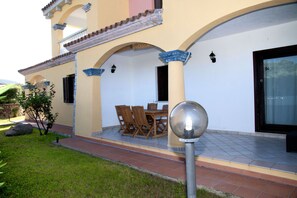 Enjoy al fresco dining on the patio with a dining table and chairs, surrounded by a beautifully maintained garden and lawn.