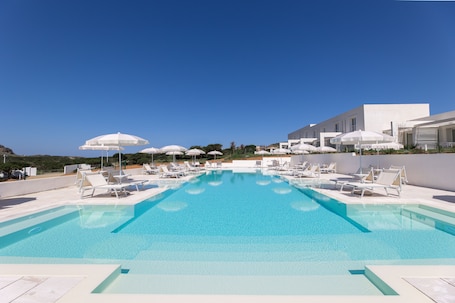 Una piscina al aire libre de temporada, sombrillas