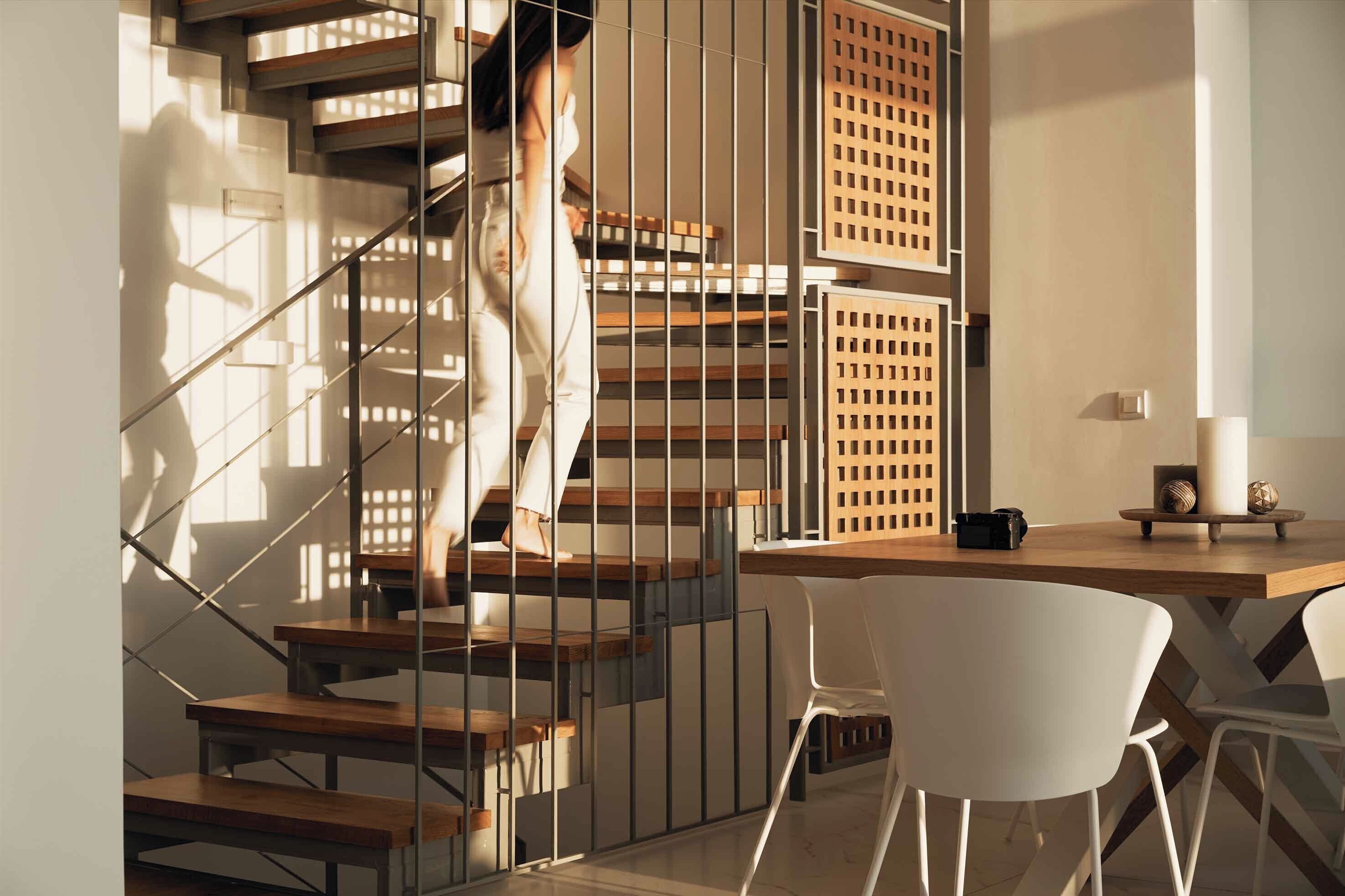 Ein modernes Interieur mit Treppe, Schreibtisch und Stuhl.