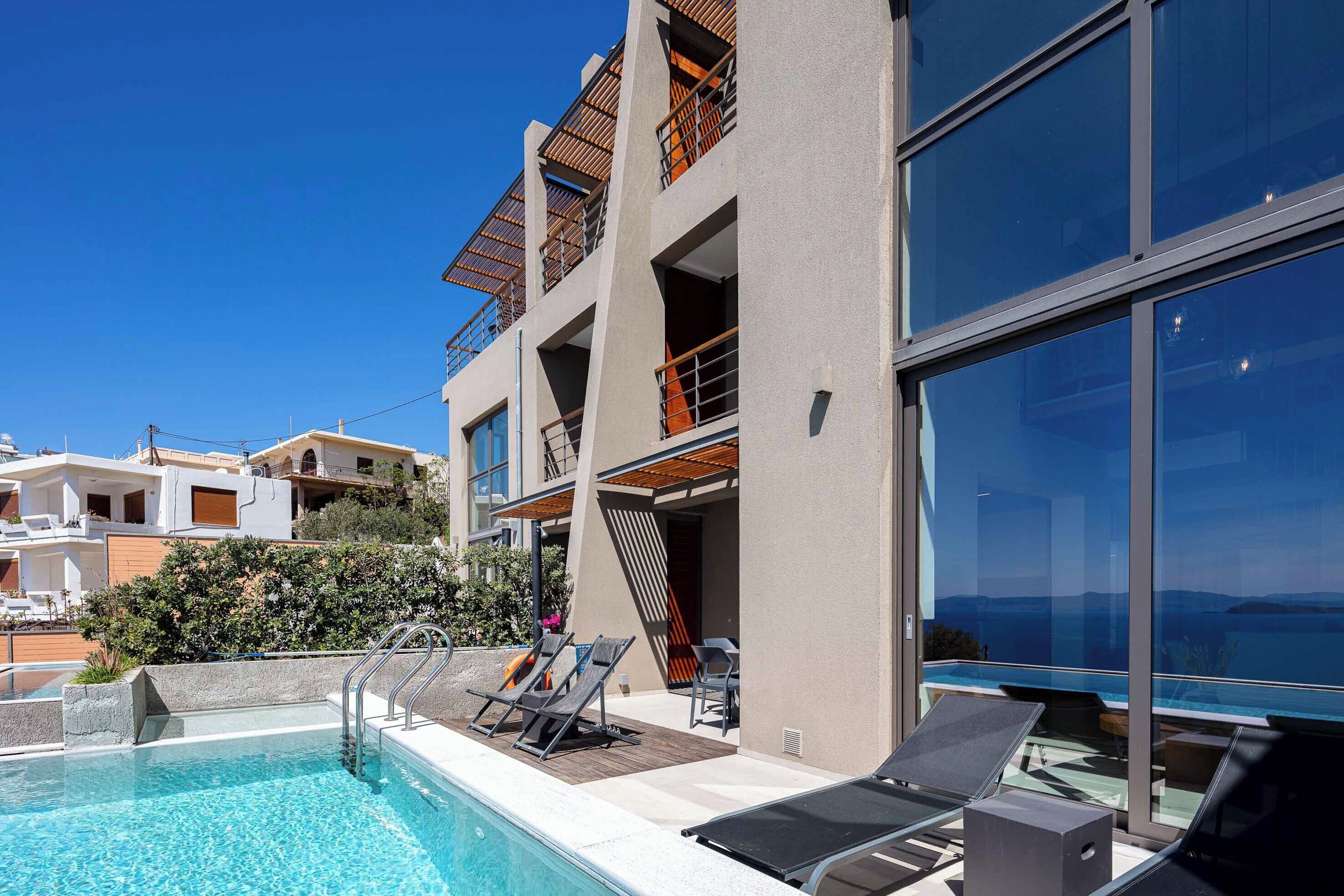 Ein modernes Gebäude mit Pool, Außenbereich und Balkonen mit Blick auf ein Gewässer.