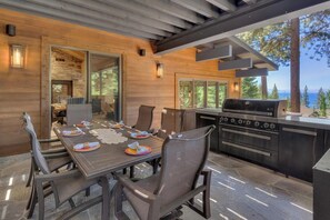 An outdoor dining area with a grill and seating.