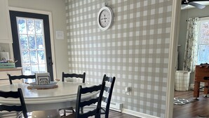 A dining area with a checkered wall, a clock, and a window with a view of trees. - Quiet, clean, jacuzzi hot tub. hidden gem, families. Skyline Park & Massanutten. (Elkton)