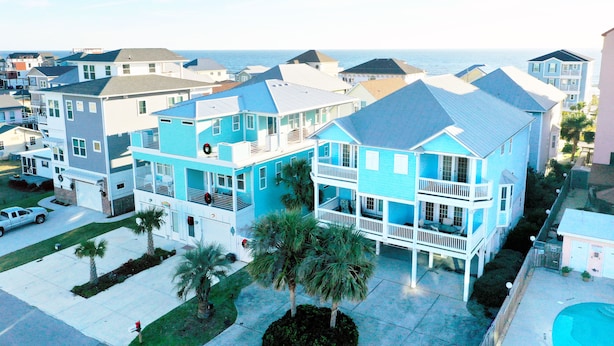 A multi-story residential building with a balcony, a garage, and a swimming pool. - Blue Bliss - 6 Bedroom Beach House -1 Block from Beach Access. Linens Included! (Carolina Beach)