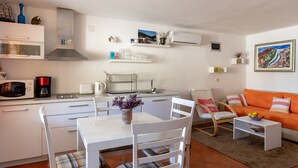 A compact living space with a kitchenette, dining area, and seating area. - Holiday Home Anima Maris (Ston)