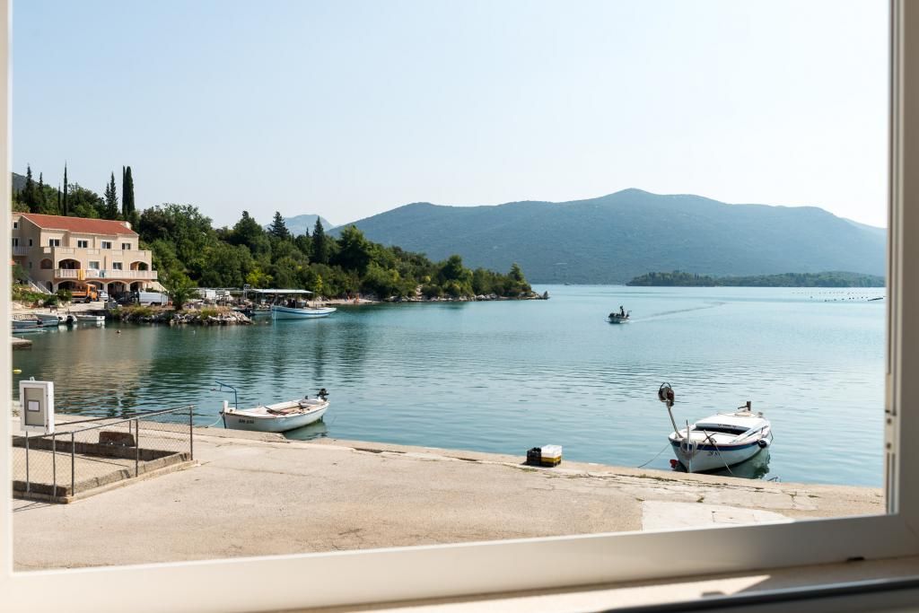 Une vue sur la côte, avec un port de plaisance, des bateaux et un bâtiment doté d’un toit rouge.