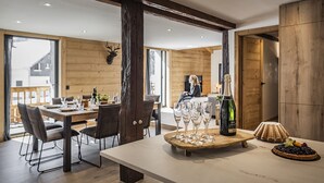 Un comedor moderno con una mesa de madera, sillas y una botella de champán.
