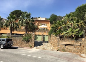 Propiedad residencial con entrada de muro de piedra, una puerta verde y un letrero que indica el nombre 'Residence Talo de Jeremy'.
