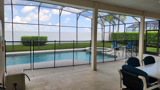 A covered pool area with a view of the pool, a table with chairs, and a power outlet. - 418 - Fabulous 4 Bed Home with South Facing Pool and Spa (Davenport)