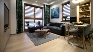 Een moderne woonkamer met een bank, salontafel en een eethoek.