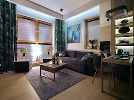 Una sala de estar moderna con sofá, mesa de centro y comedor.