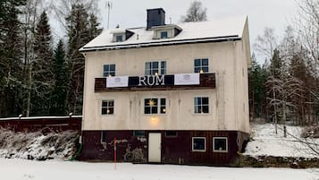 En tvåvåningsbyggnad med en skylt som visar orden "RUM" och "HOTEL VILLA BERGI".