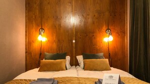 Ein Doppelbett mit einer gesteppten Bettdecke, zwei Kissen, einem gefalteten Handtuch und einem Schild auf dem Bett.