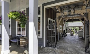 A stone pathway leading to a bar area with a rustic wooden archway and metal gates.