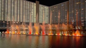 Vista nocturna de un hotel con un gran espectáculo de fuentes.