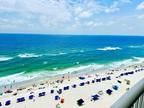 A beach with umbrellas and people.