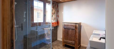 Une salle de bain moderne avec une douche à parois de verre, un meuble en bois et un lavabo.