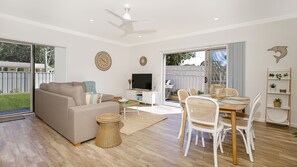 Relax in this spacious living area with a sofa, flat-screen TV, and dining table.