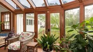 A covered patio with wicker furniture, potted plants, and a view of a house and yard. - The Green Room unit 4-Private Suite, Starry Skies -20 mins to Wells & Ogunquit (North Berwick)